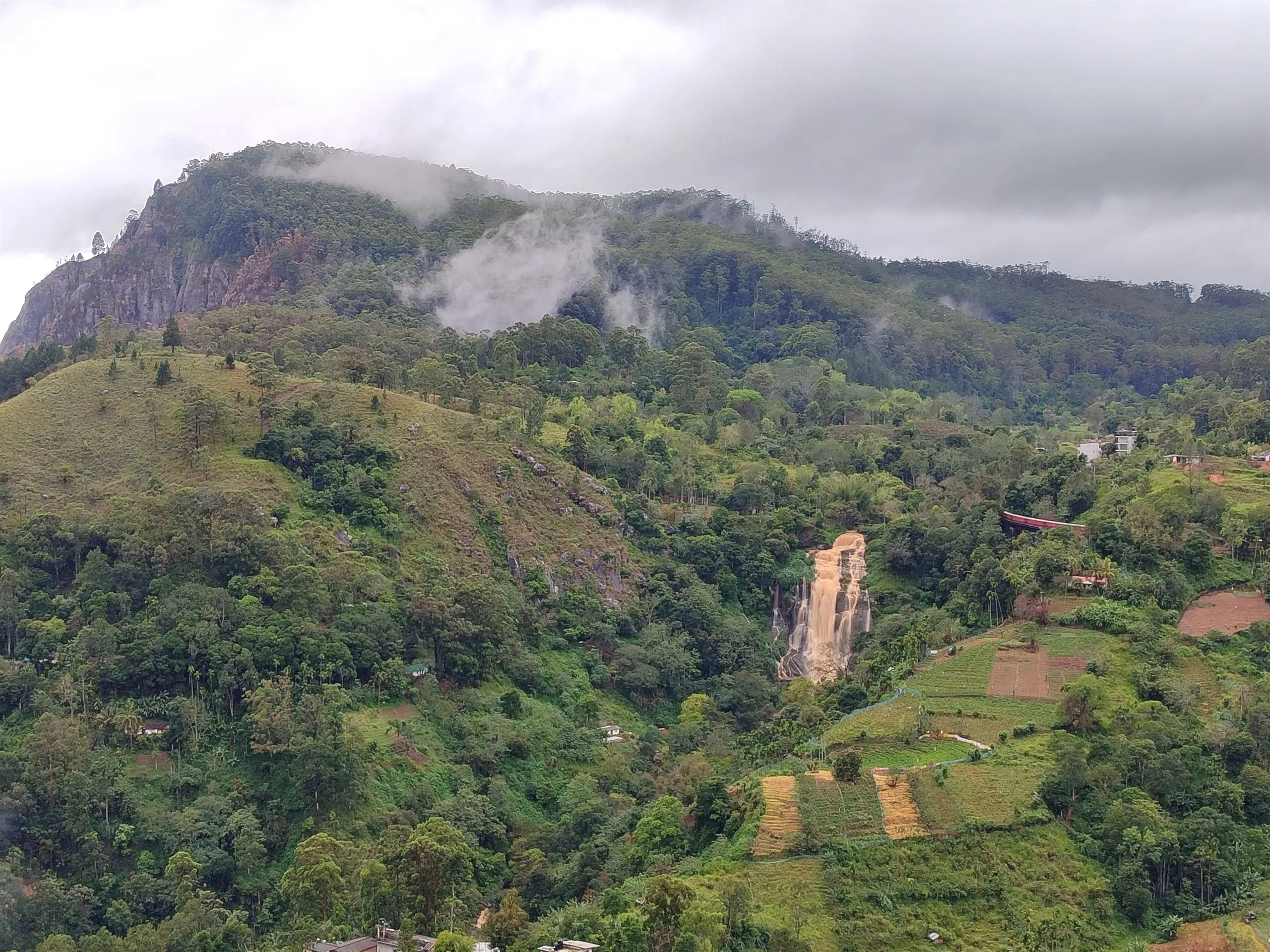 Bergland im Morgennebel, ein Wasserfall am gegenüberliegenden Hang