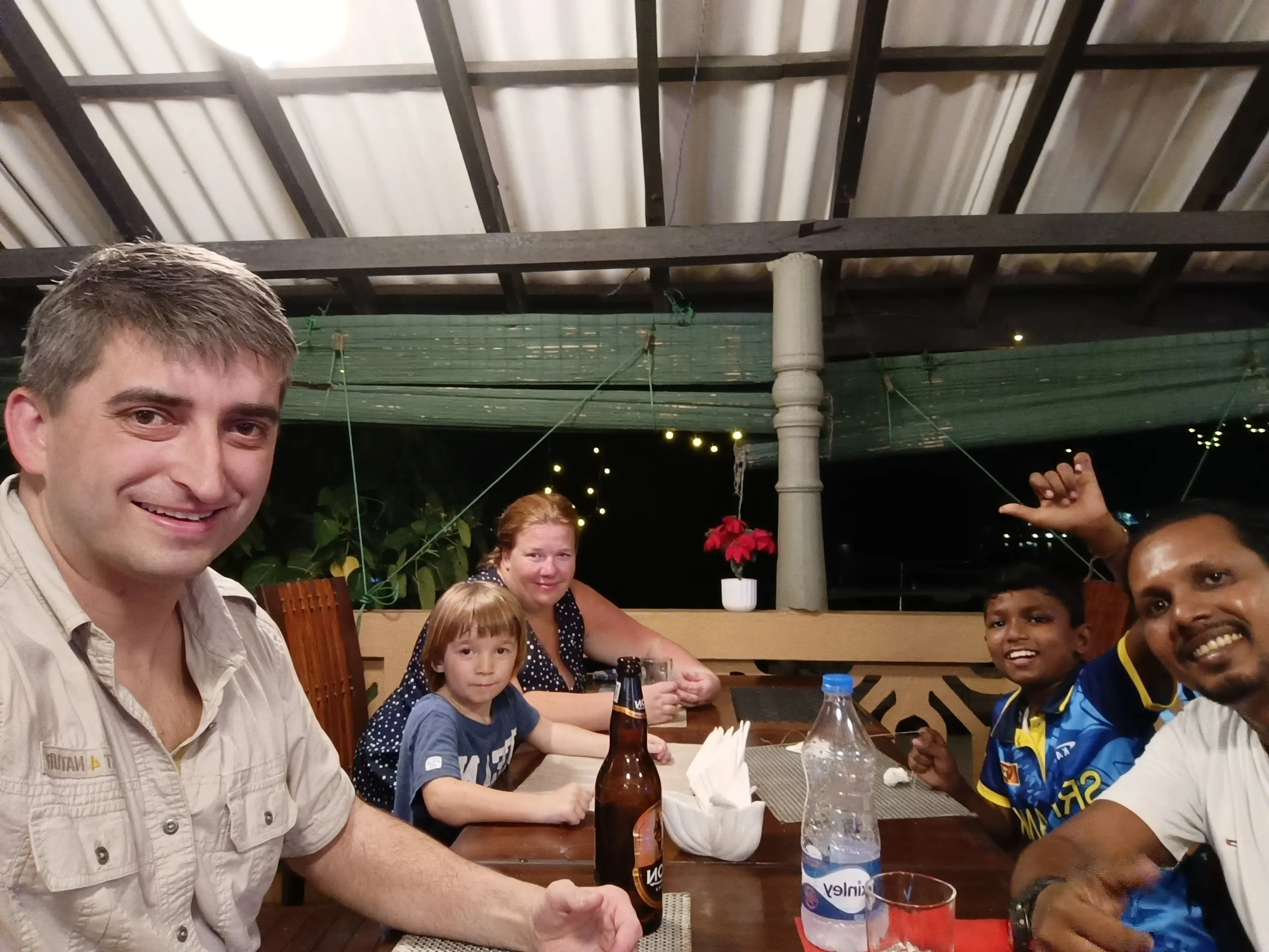 Zwei Familien an einem langen Tisch in einem offenen Restaurant am Abend
